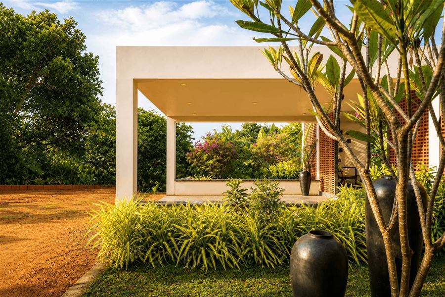 Kishore Farmhouse side elevation — terracotta roof and landscaped surrounds